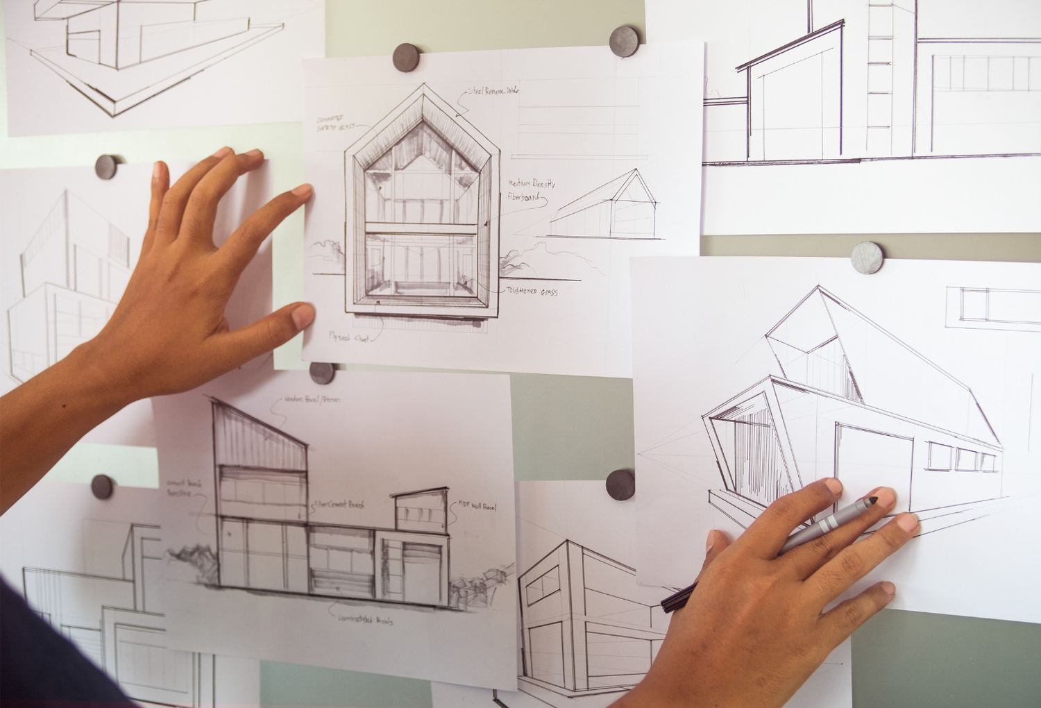Design sketches and elevations pinned up for review